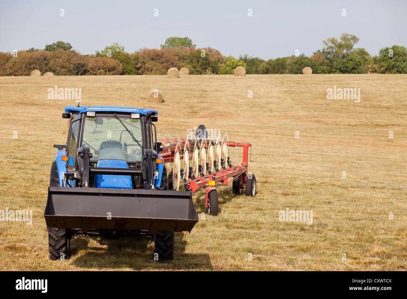 Tractor and thresher in crop field Stock Photo