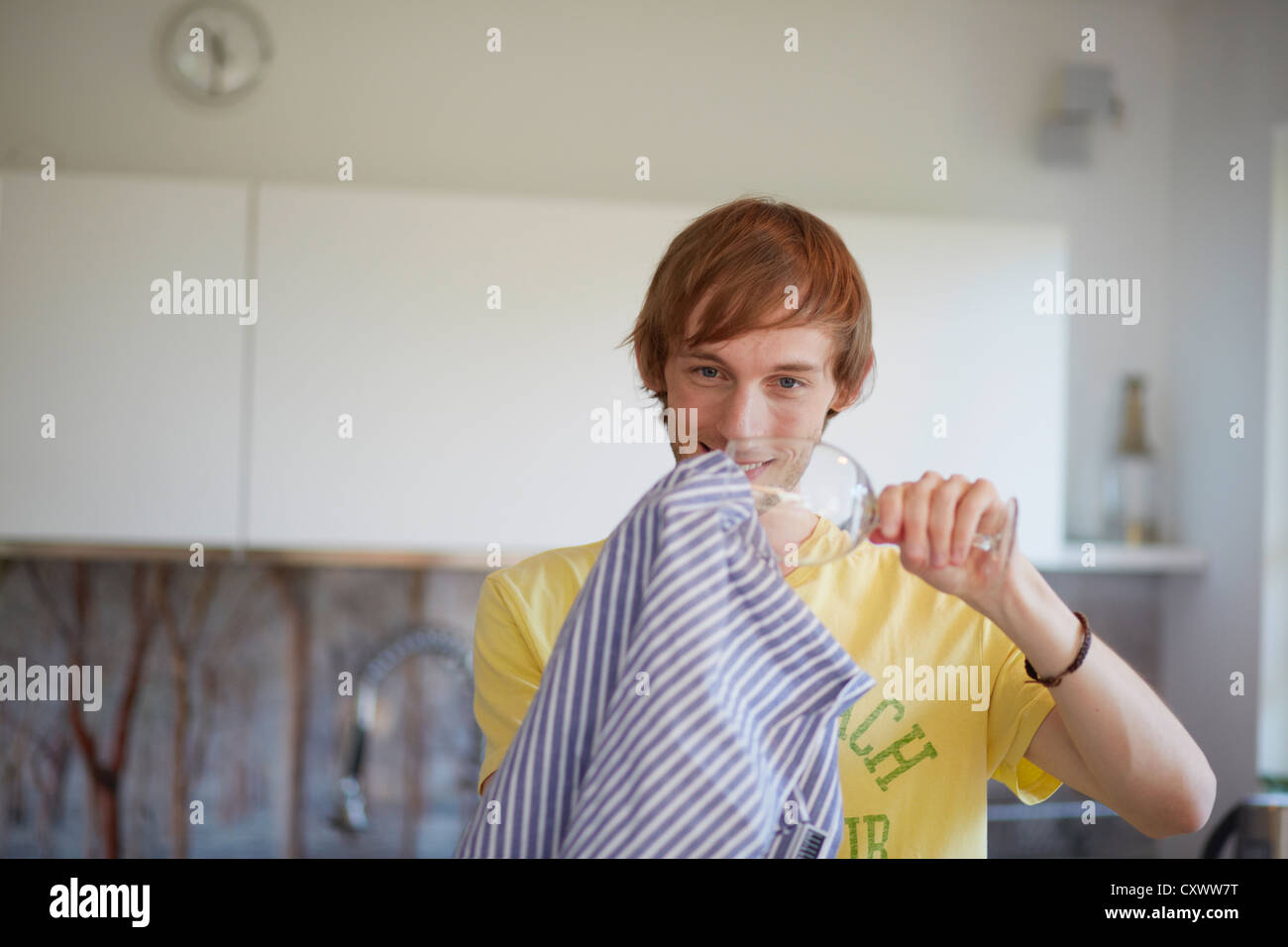 Man polishing wine glass in kitchen Stock Photo Alamy