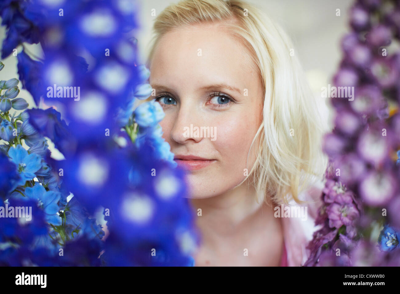 Close up of woman with tall flowers Stock Photo