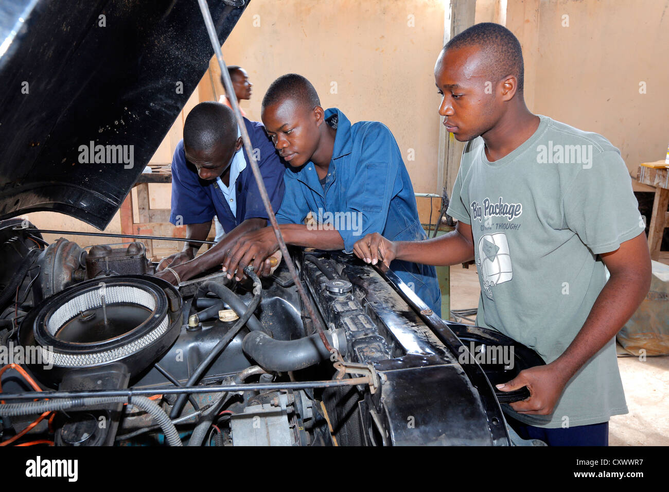 young mechanics works on a car engine. Machui Vocational Center, Machui, Zanzibar, Tanzania Stock Photo