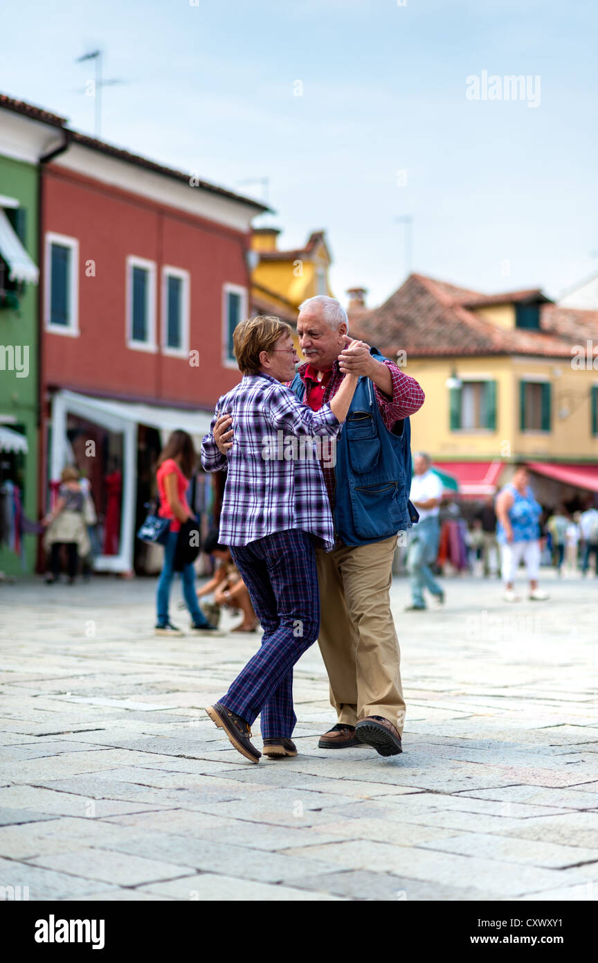 Elderly pair dancing waltz on Burano square Stock Photo