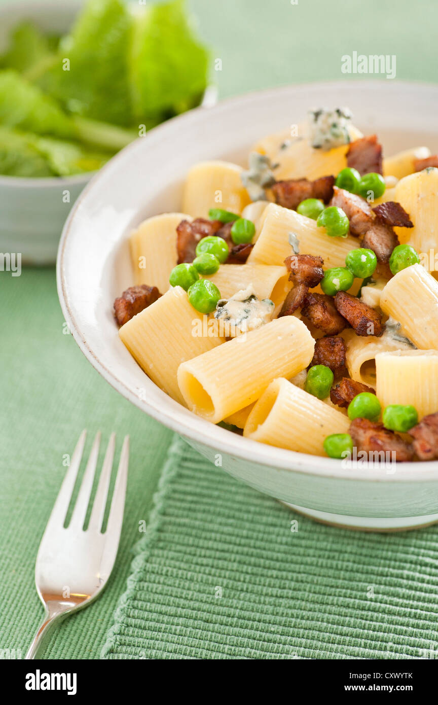 Closeup of a bowl of white pasta served with peas, bacon and blue cheese Stock Photo