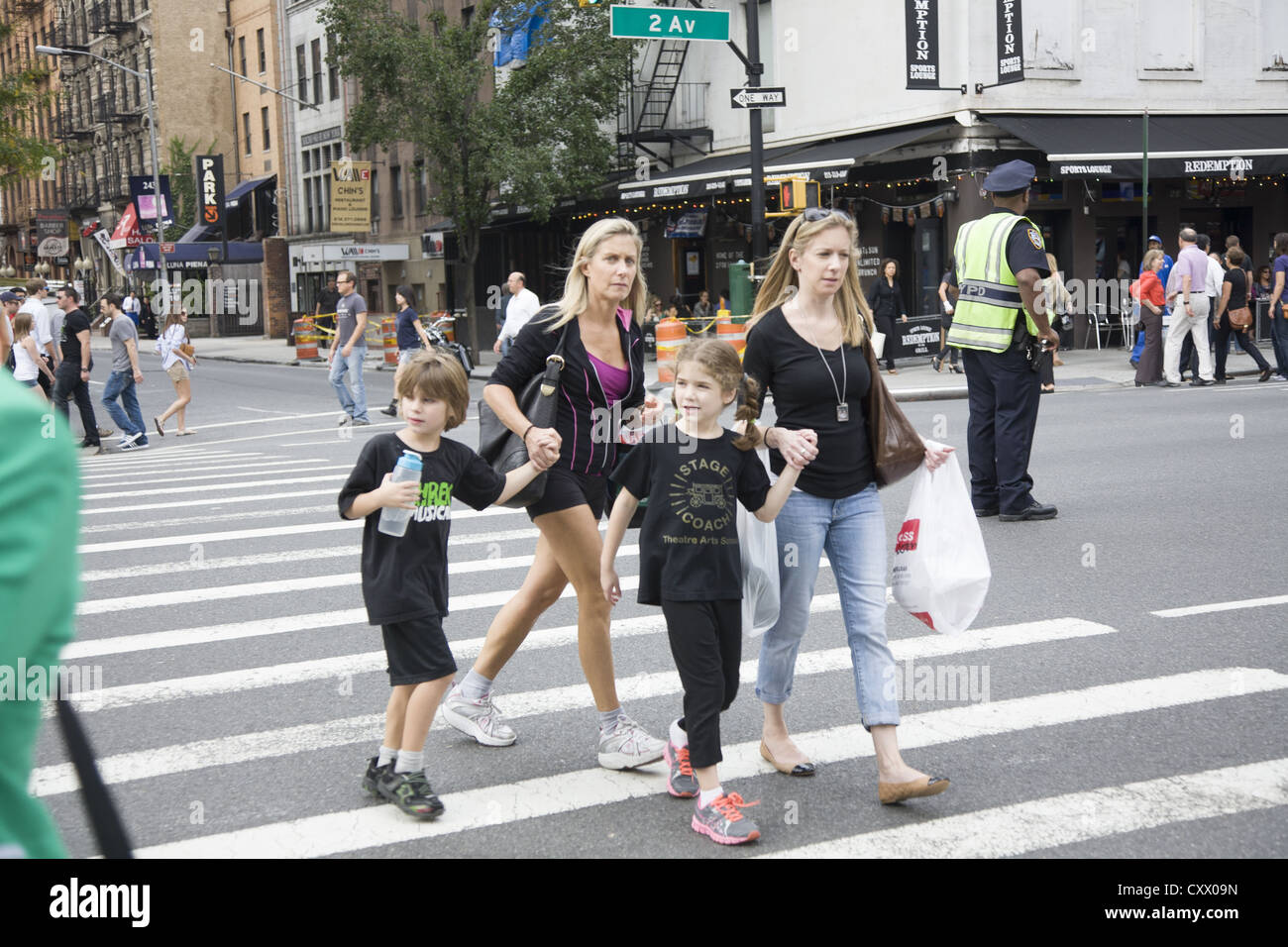 Mothers with kids cross 2nd Avenue on the est side of Manhattan. Stock Photo