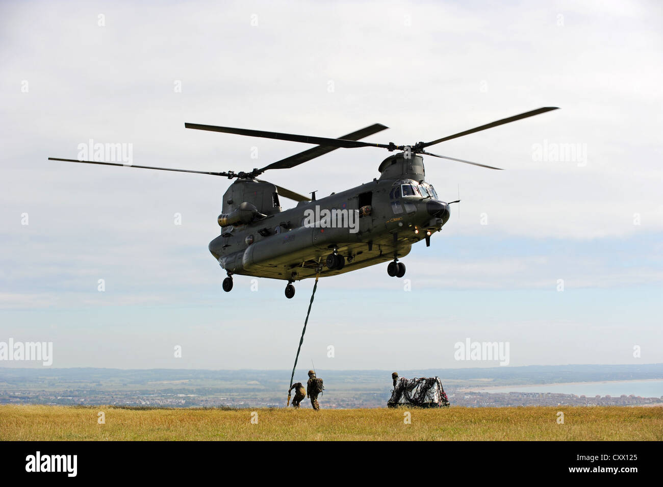 A Chinook Helicopter flies in the six tonne granite Bomber Command memorial to Beachy Head Stock Photo