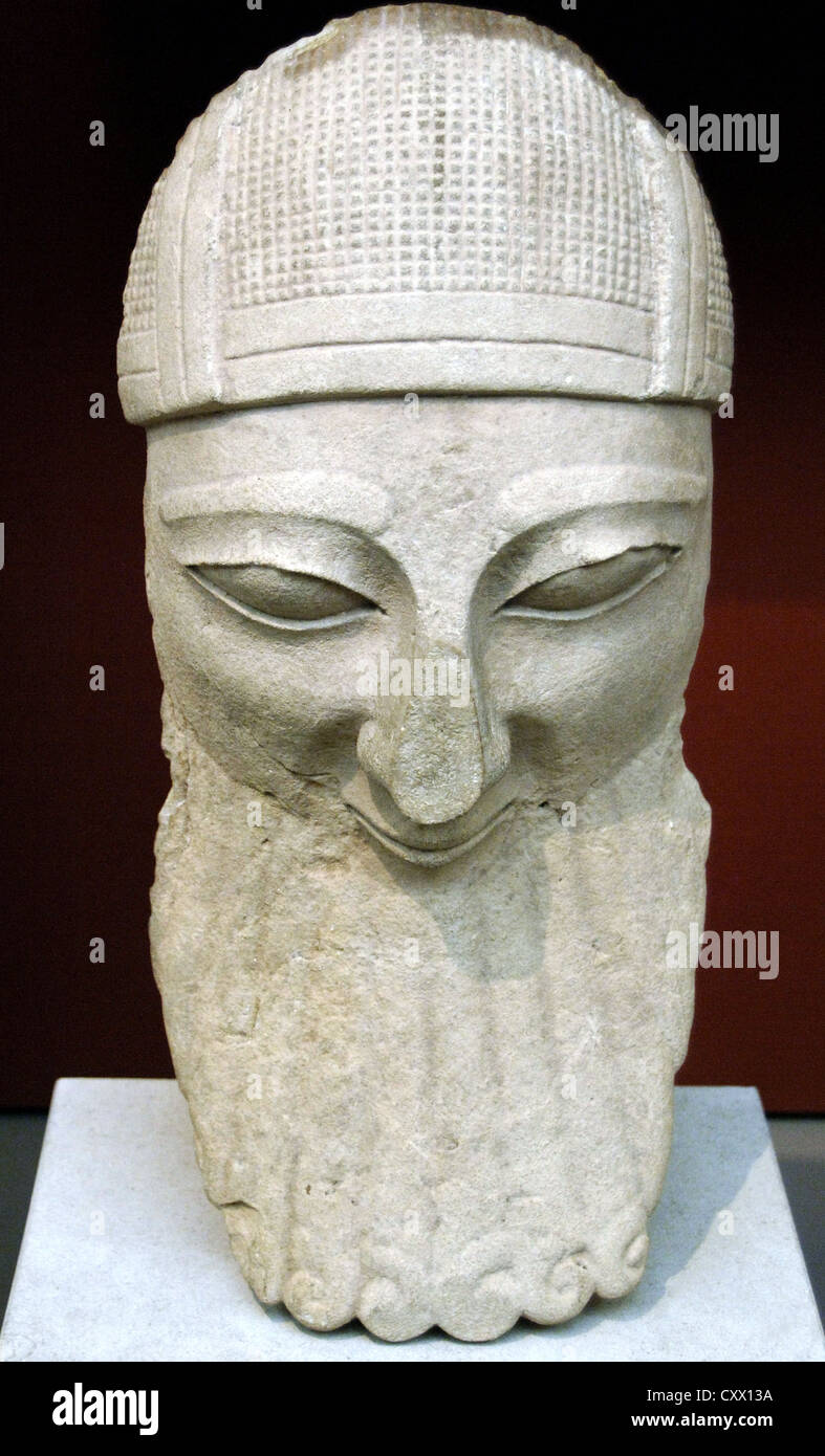 Head from a colossal statue of a bearded worshipper with helmet. Limestone. Made in Cyprus. 570-550 BC. From Byblos. Stock Photo