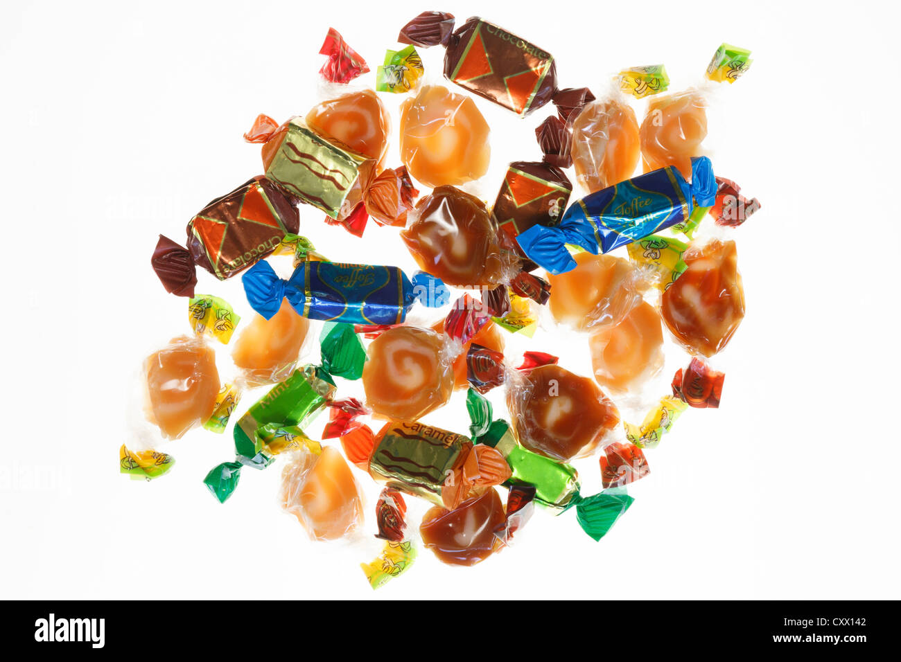 A selection of toffees wrapped in cellophane and backlit on a white background Stock Photo
