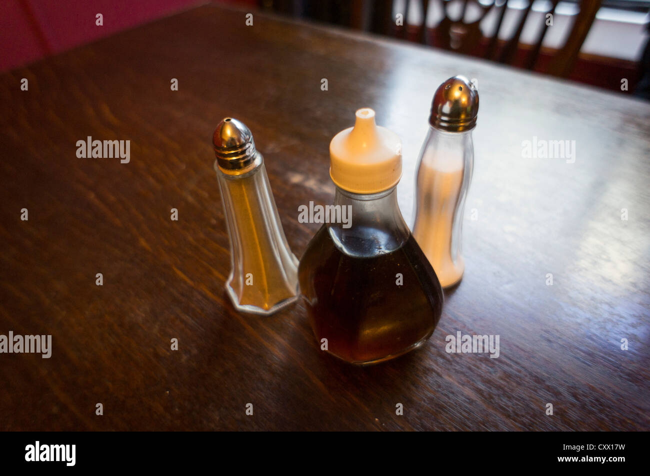 Condiments salt, pepper and vinegar on a pub restaurant table Stock
