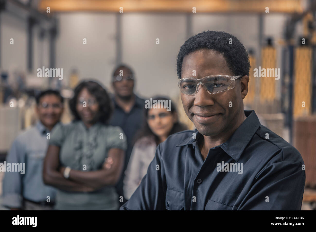 Workers standing together in factory Stock Photo - Alamy