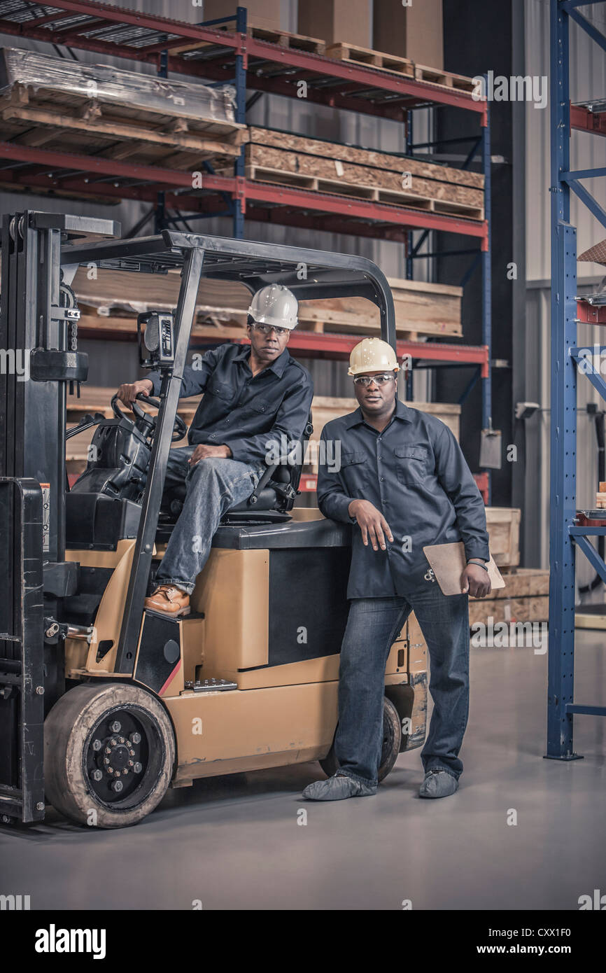 African American workers with forklift in factory Stock Photo Alamy