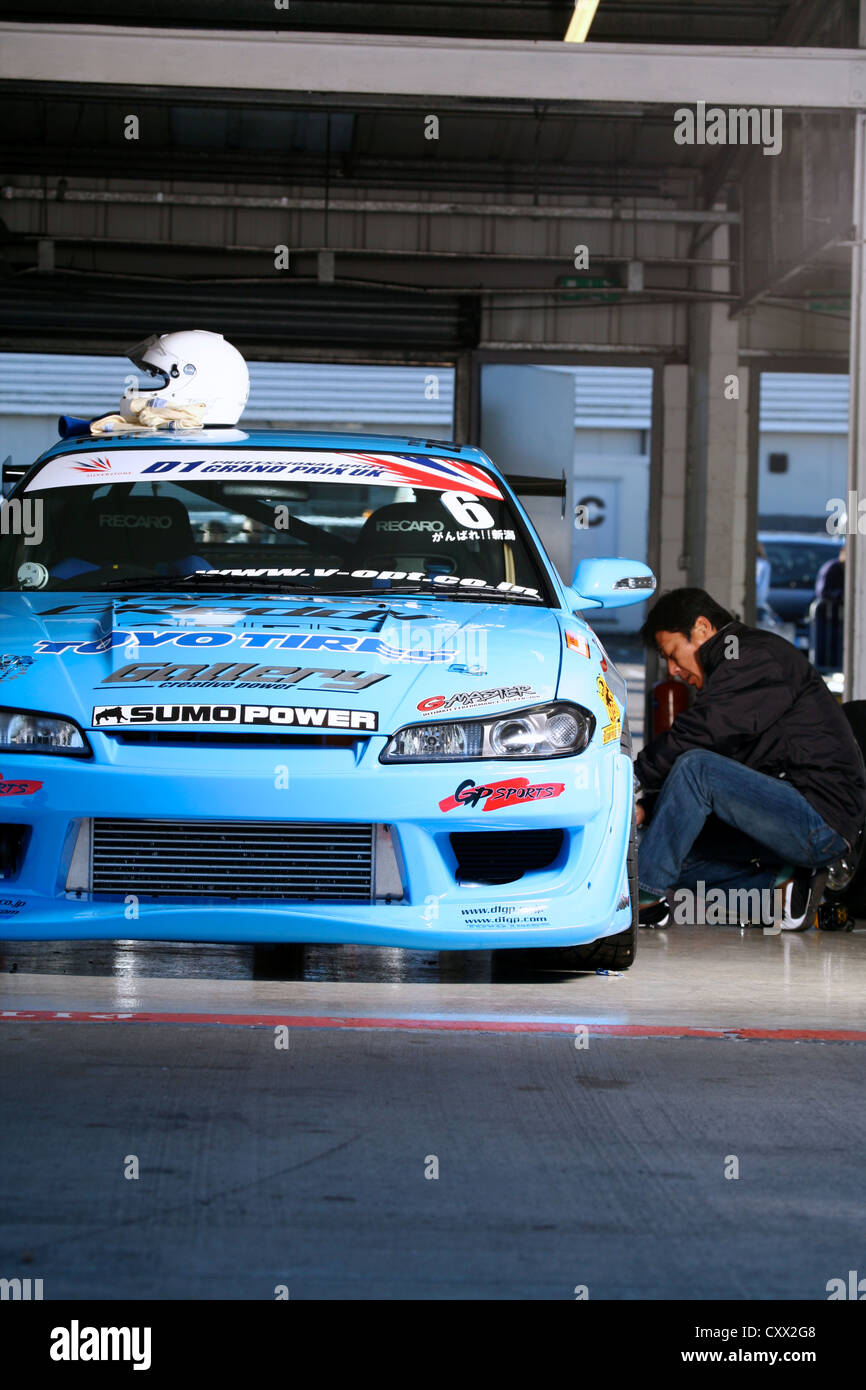 Portrait of team mechanic changing tyre on race car Stock Photo - Alamy