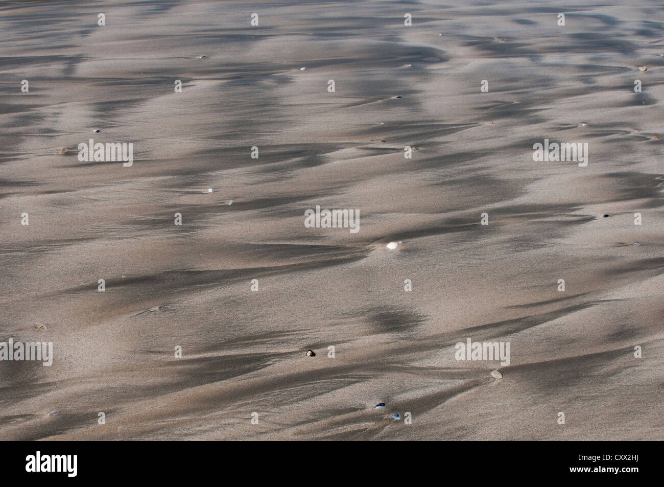Beach patterns caused by the retreating tide leaving rivulets and meanders in the sand, Stock Photo