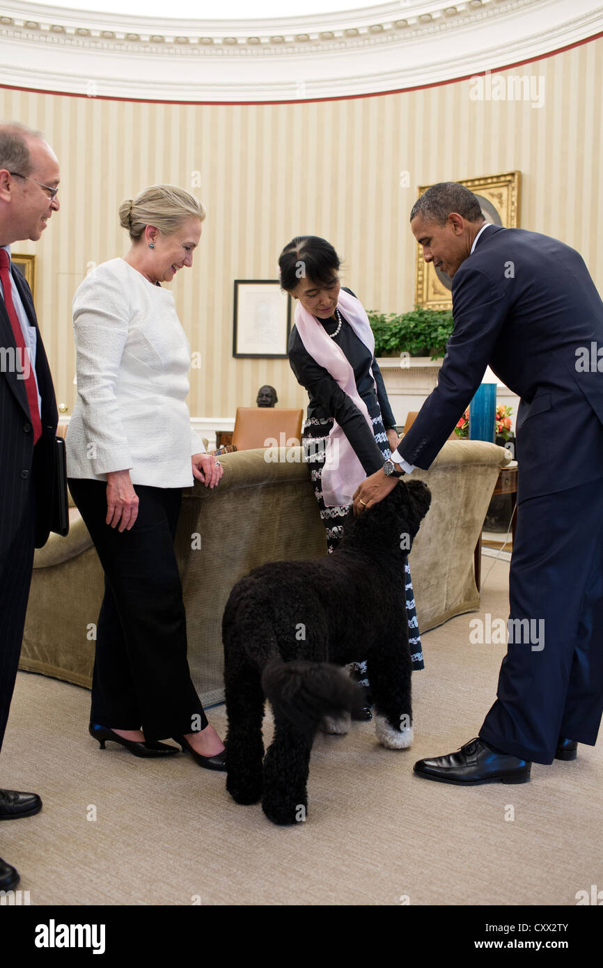 US President Barack Obama and Burmese Opposition Leader Aung San Suu Kyi pet Bo the Obama family dog at the conclusion of their meeting September 19, 2012 in the Oval Office. Danny Russel, Senior Director for Asian Affairs and Secretary of State Hillary Rodham Clinton watch at left. Stock Photo