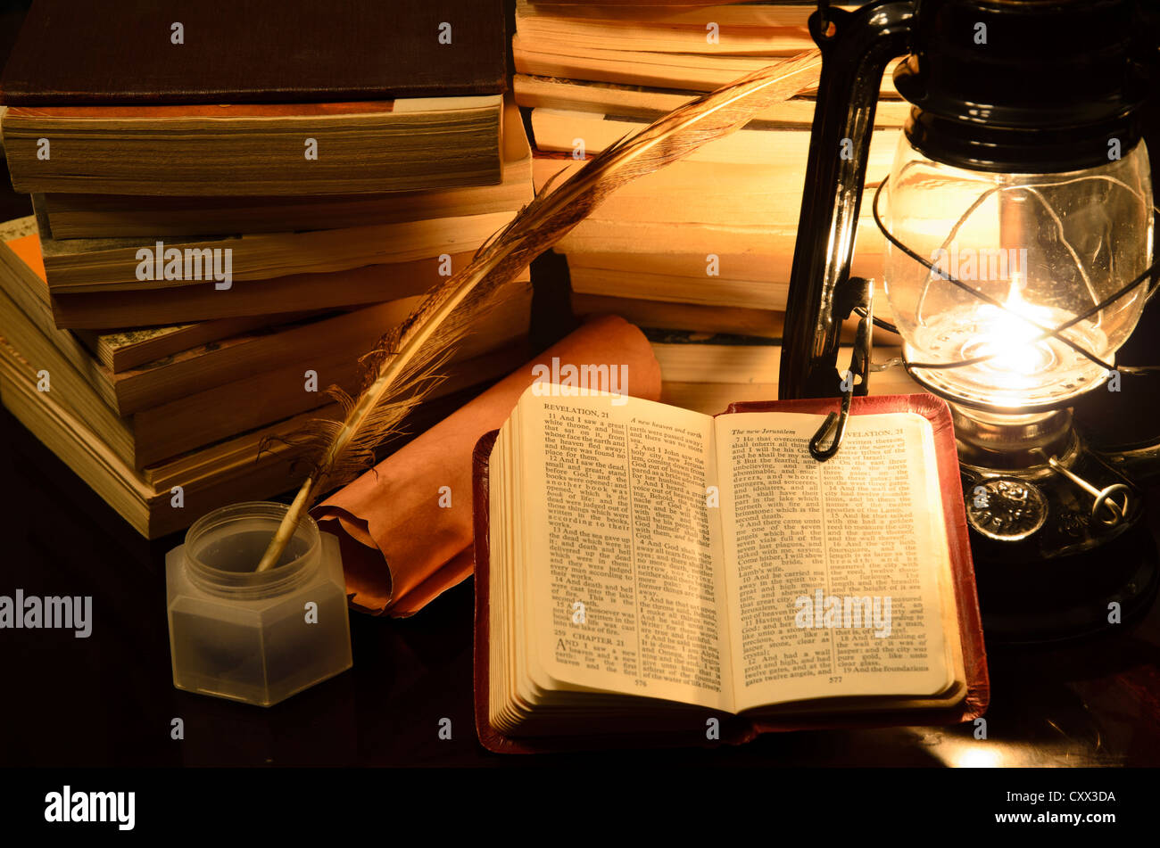a bible surrunded by books in a lamp light Stock Photo Alamy