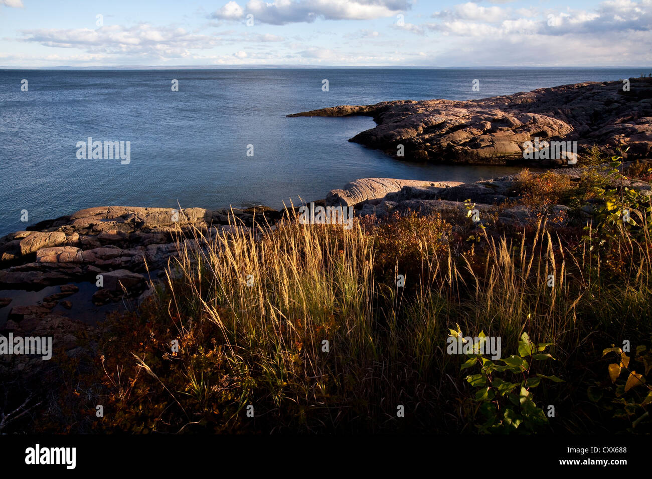 The sun sets on the rocky seashore and the intertidal zone of the St. Lawrence river in Essipit and Les Escoumins Stock Photo