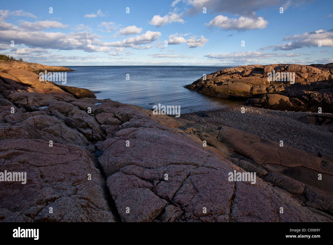 The sun sets on the rocky seashore and the intertidal zone of the St. Lawrence river in Essipit and Les Escoumins Stock Photo