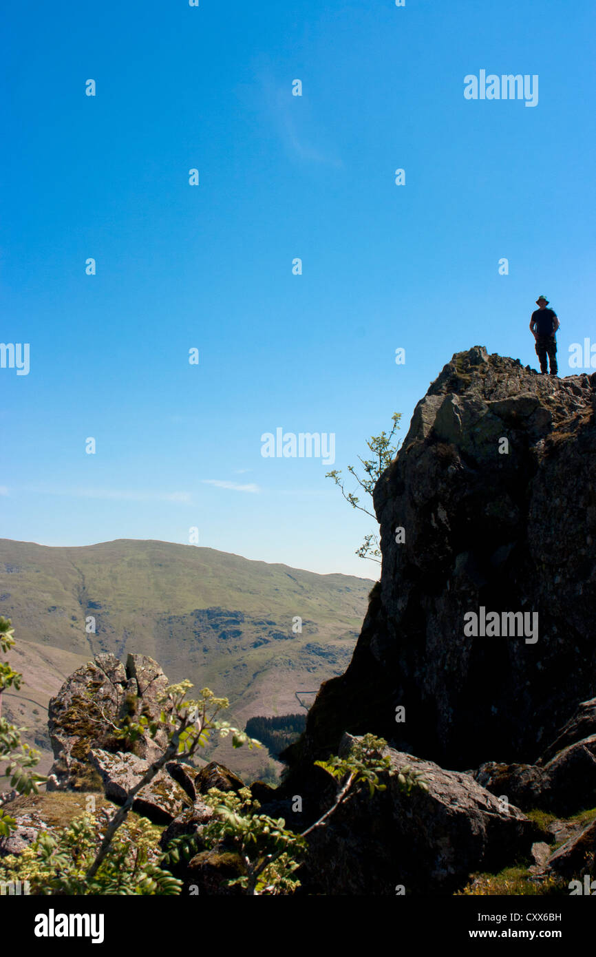 Fell walker on the "lion" rock on summit of Helm Crag the rocks being
