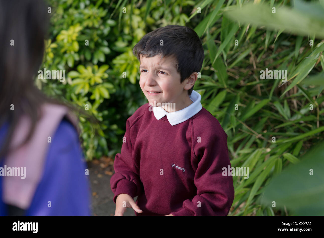 boy in primary school being bullied by an older pupil Stock Photo
