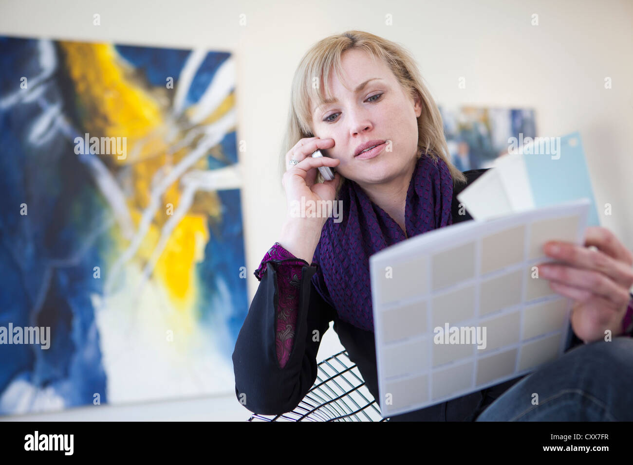 Caucasian art gallery owner talking on cell phone Stock Photo