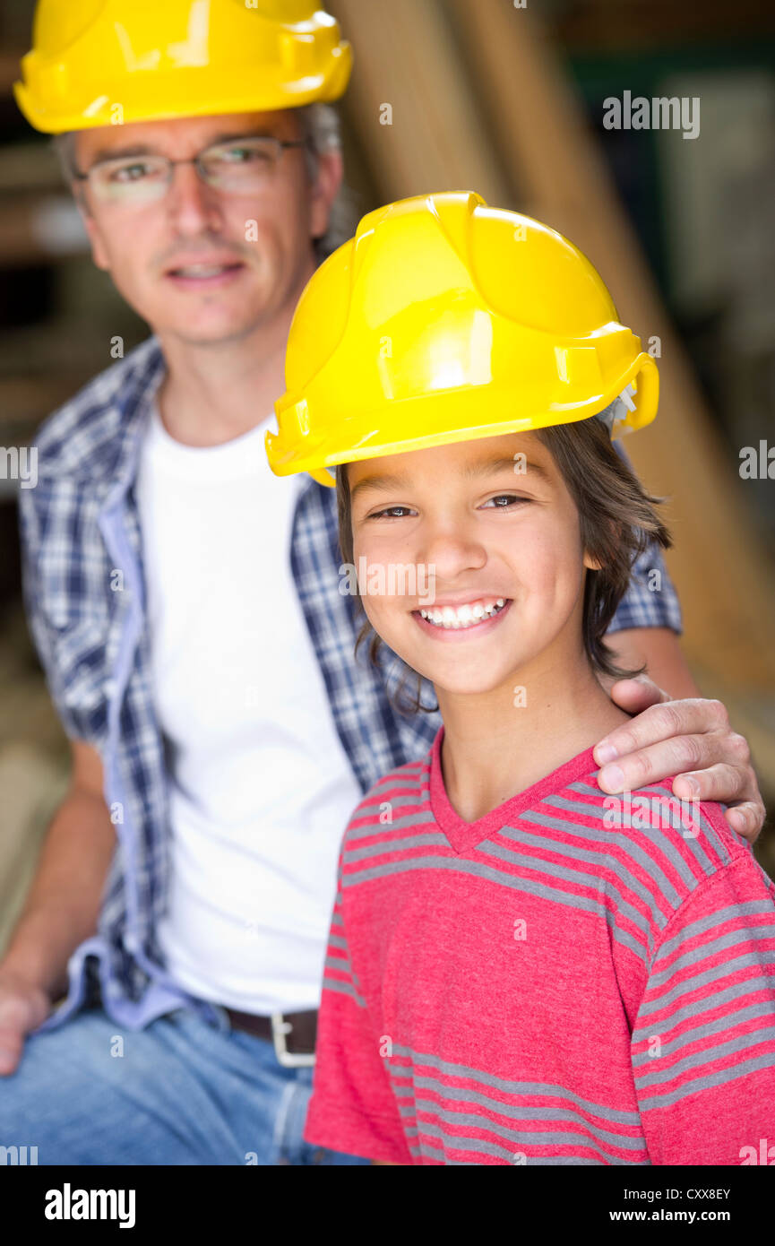 Hispanic carpenter and son in hard hats Stock Photo Alamy