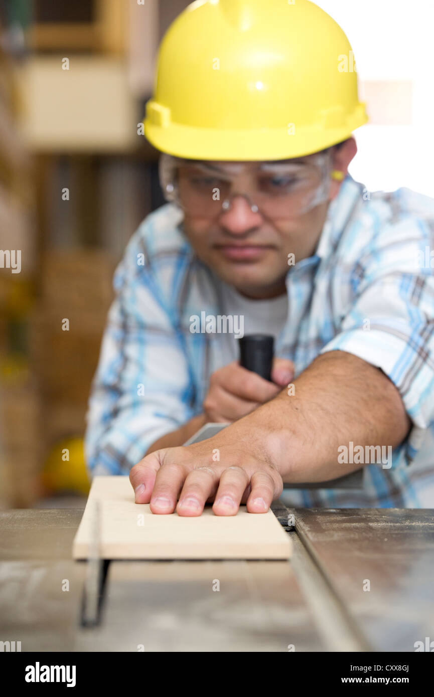 Hispanic carpenter cutting wood with table saw Stock Photo Alamy