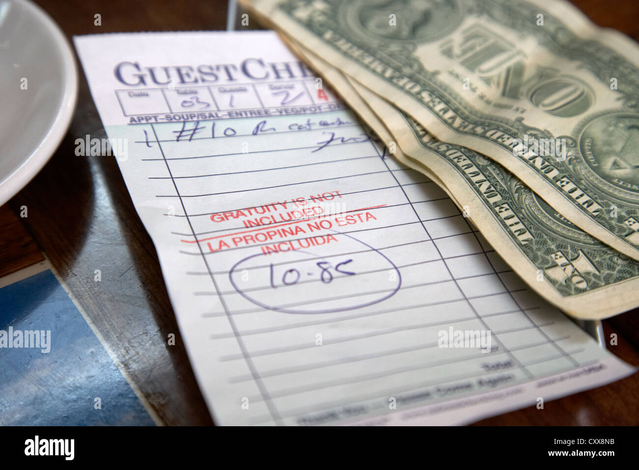 guest check with gratuity not included notice with cash and tip in a cuban restaurant miami south beach florida usa Stock Photo