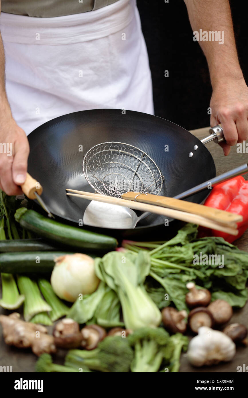 Caucasian chef with wok and fresh vegetables Stock Photo