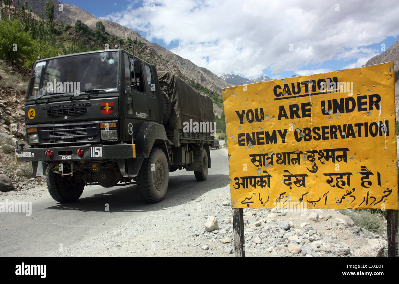 Indian army convoy passes military warning sign on the hazardous Kargil road close to Pakistan frontier, Kashmir, India Stock Photo