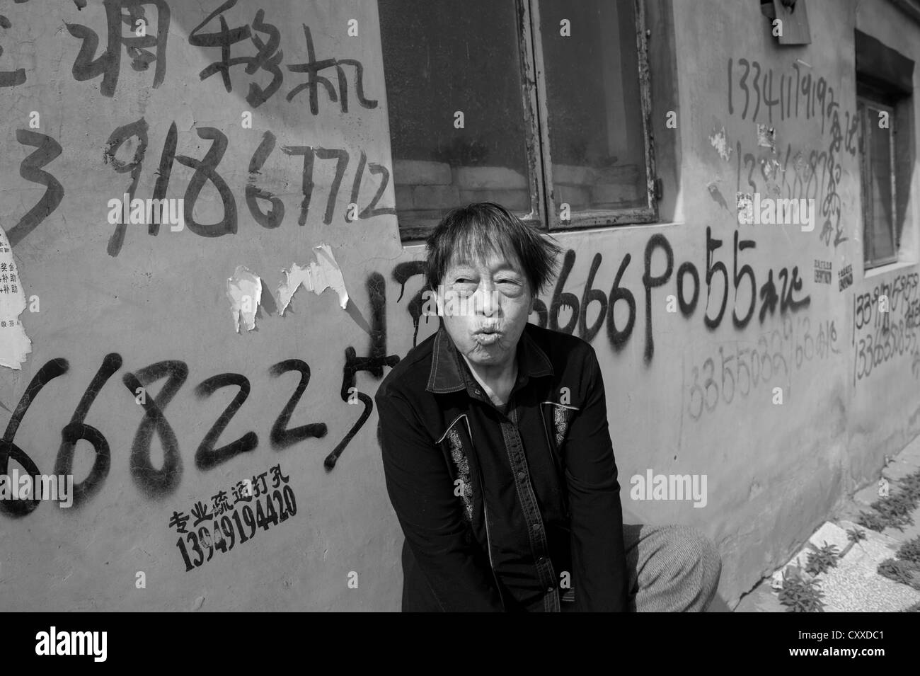 Jiugong, Beijing. Mrs. Li Shulan sitting in front of her house that is designated for destruction. She refuses to leave. Stock Photo
