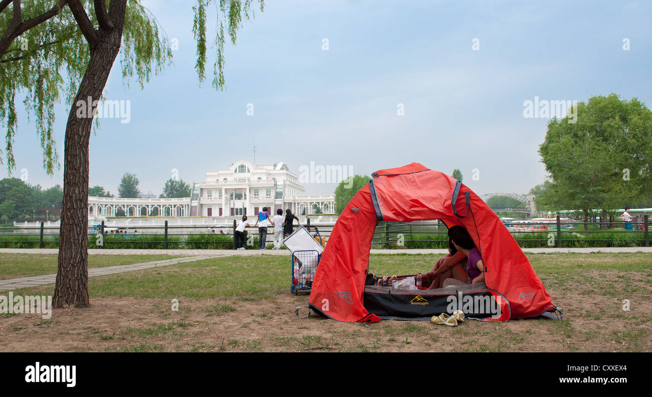 Chaoyang Park, Beijing. Family in a - rented for a day - tent. Stock Photo