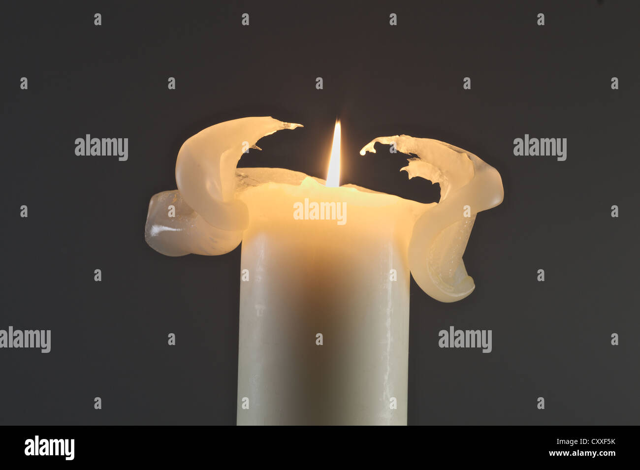 White candle burning, deformed wax Stock Photo Alamy