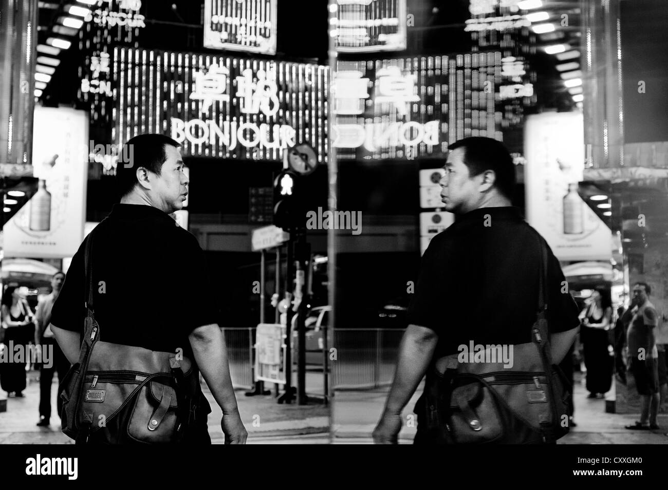 Kowloon, Hong Kong. Street scene at night with reflection in a shop window. Stock Photo