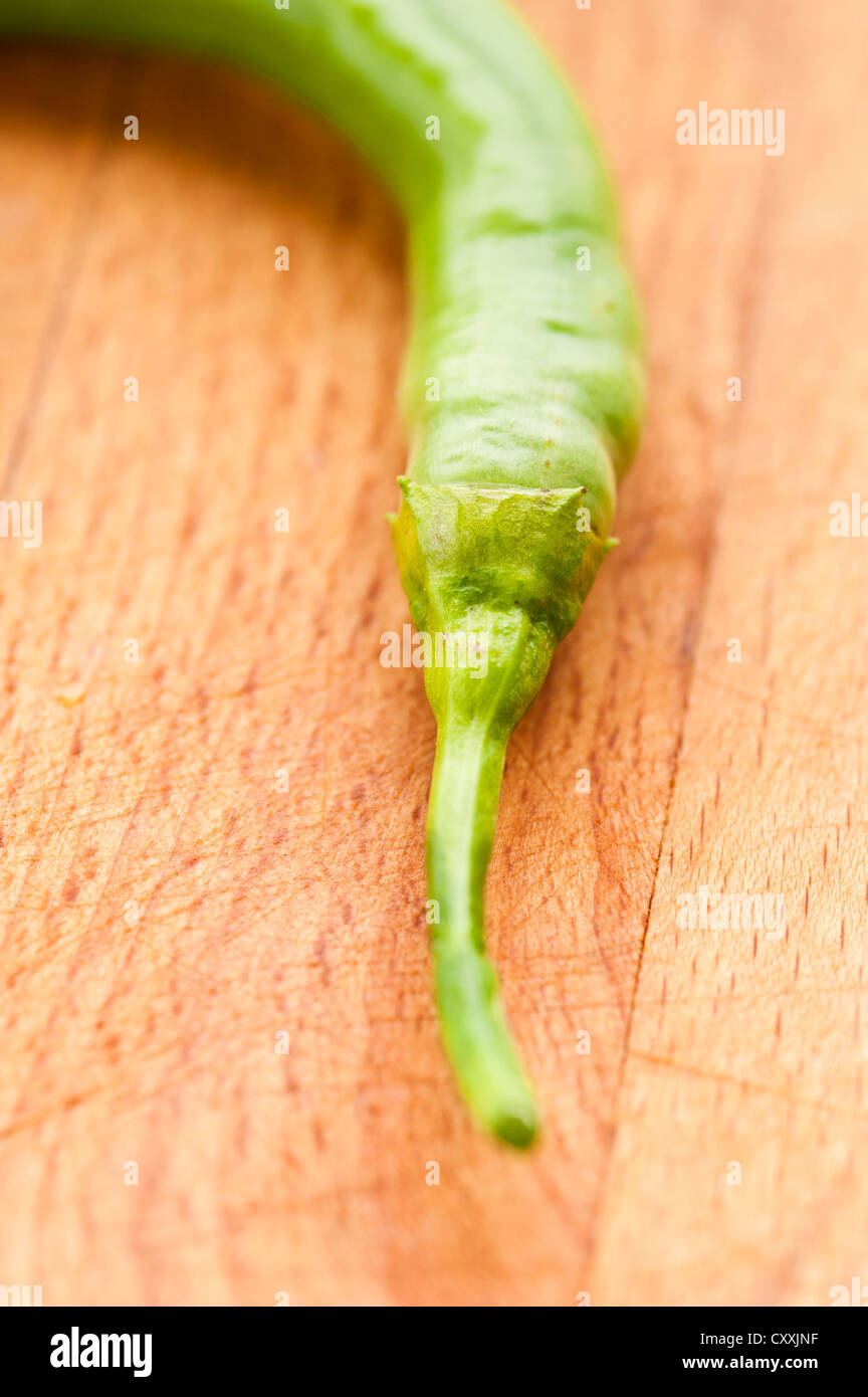 Closeup of green chili pepper on wooden cutting board Stock Photo