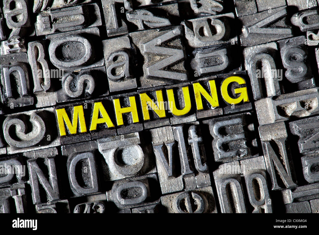 Old lead letters forming the word 'Mahnung', German for reminder Stock Photo