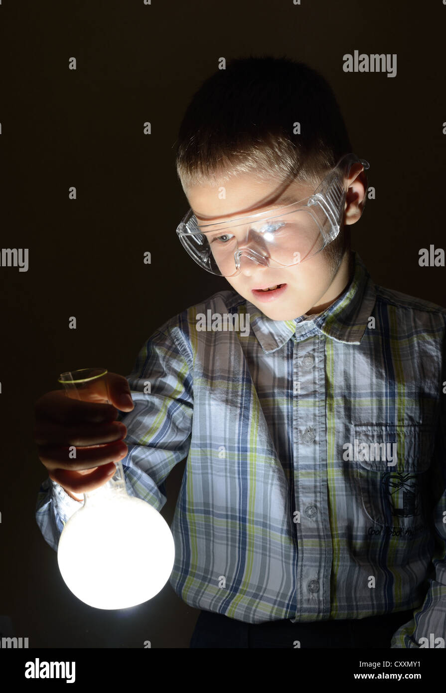 schoolboy holding glowing bulb Stock Photo