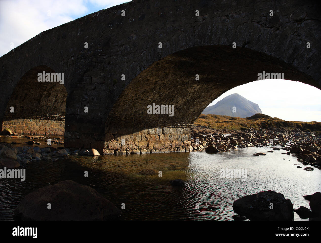A mountain in the Cuillin Range on the Isle of Skye in the Scottish Highlands seen through an arch of the Sligachan Bridge. Stock Photo