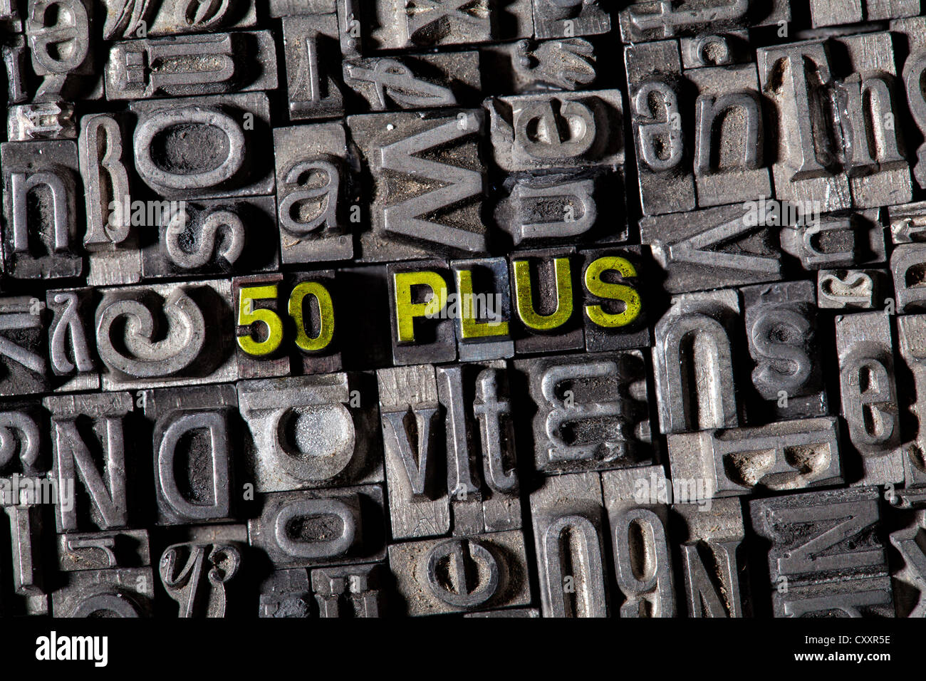 Old lead letters spelling the word '50 PLUS' Stock Photo