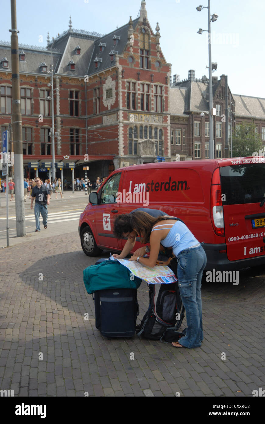 tourists looking at map in front of Amsterdam Central Station, Stock Photo