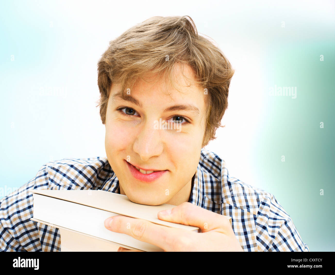 Smiling student with a stack of books Stock Photo - Alamy