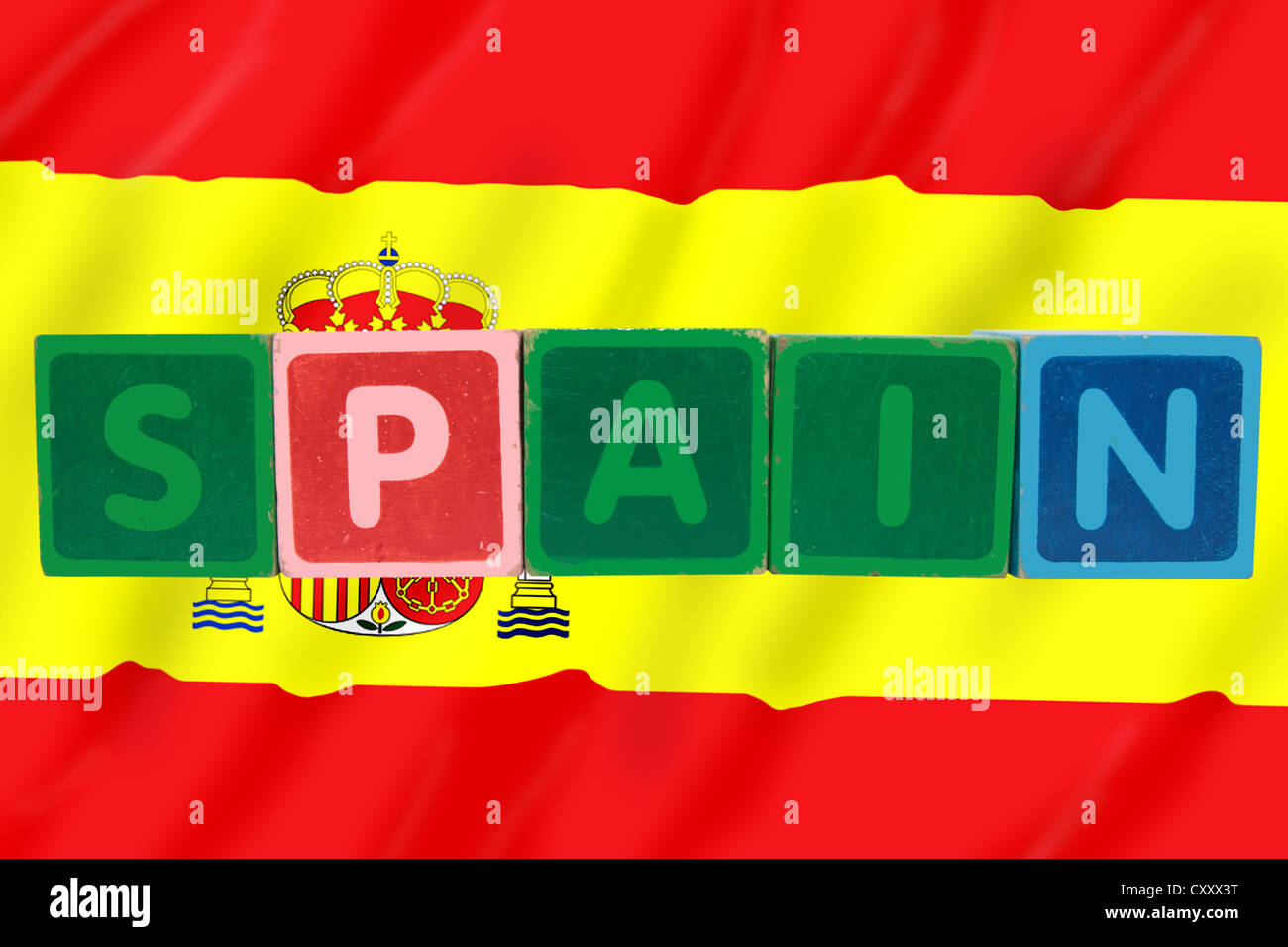 toy letters that spell spain against a flag background with clipping path Stock Photo