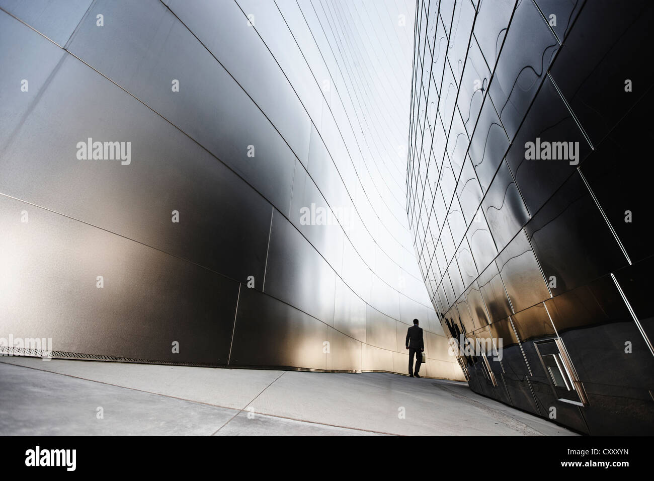 Businessman walking in urban alley Stock Photo - Alamy