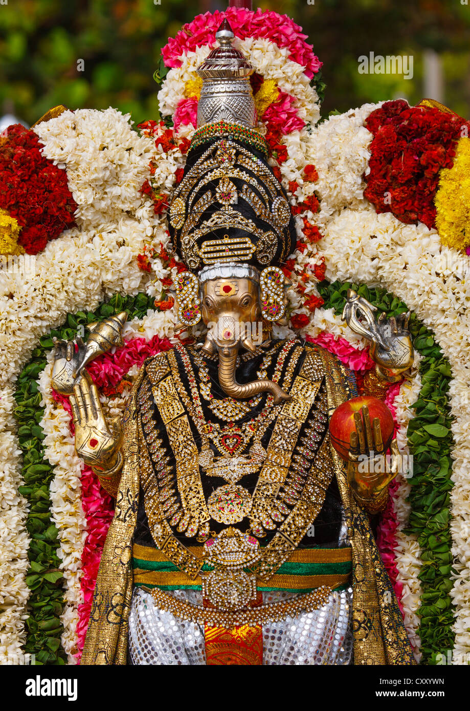 Golden Statue Of Lord Ganesha Adorned With Flowers And Holding An