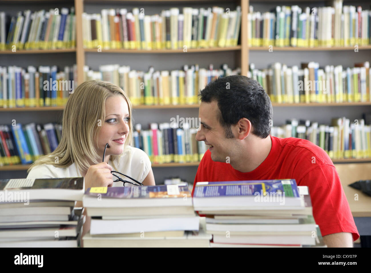 Female and male students, stacks of books, university library Stock ...