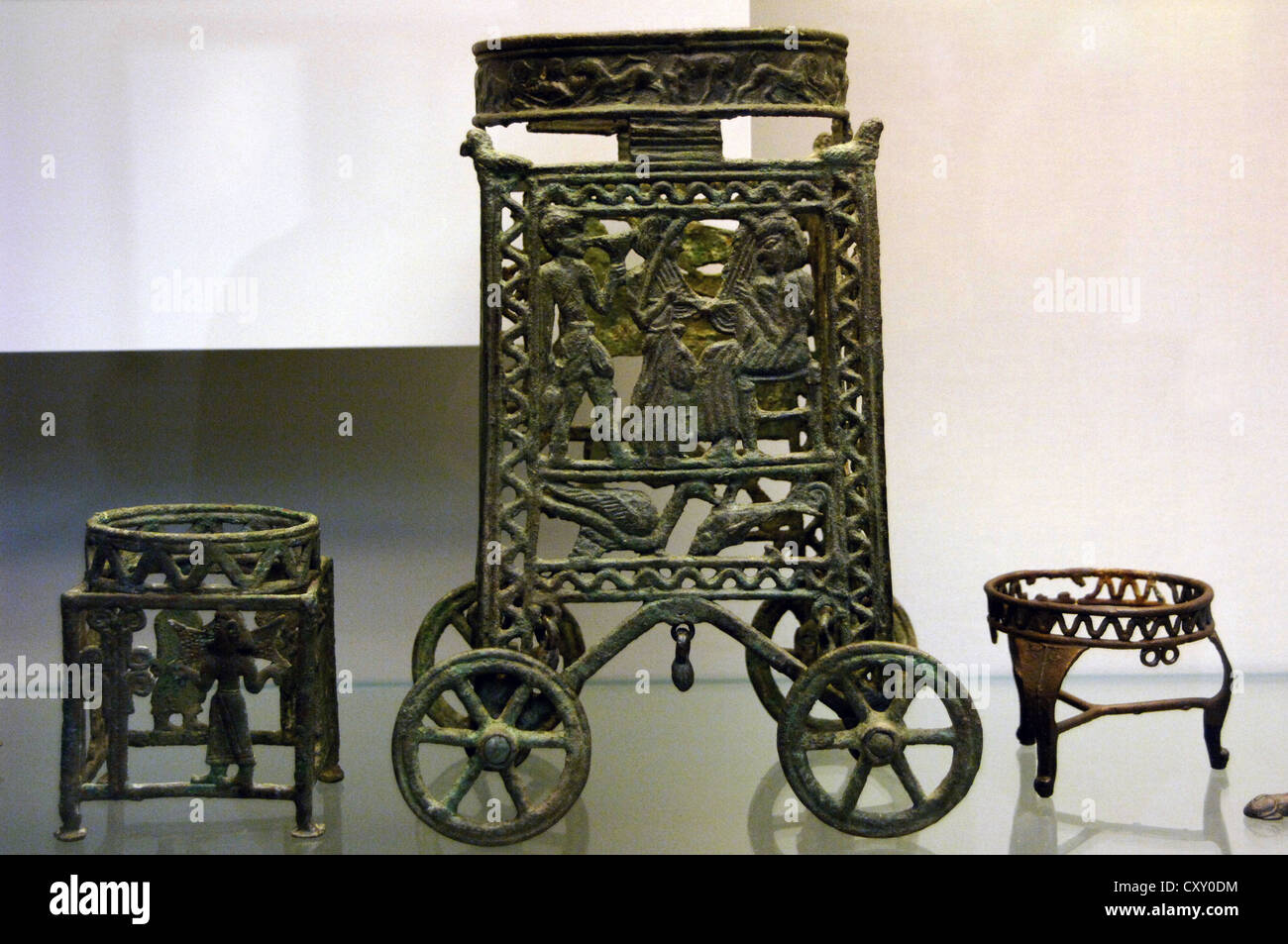 Wheeled stand for a vessel with an animal frieze on the ring depicting a seated figure playing a stringed instrument. Bronze. Stock Photo