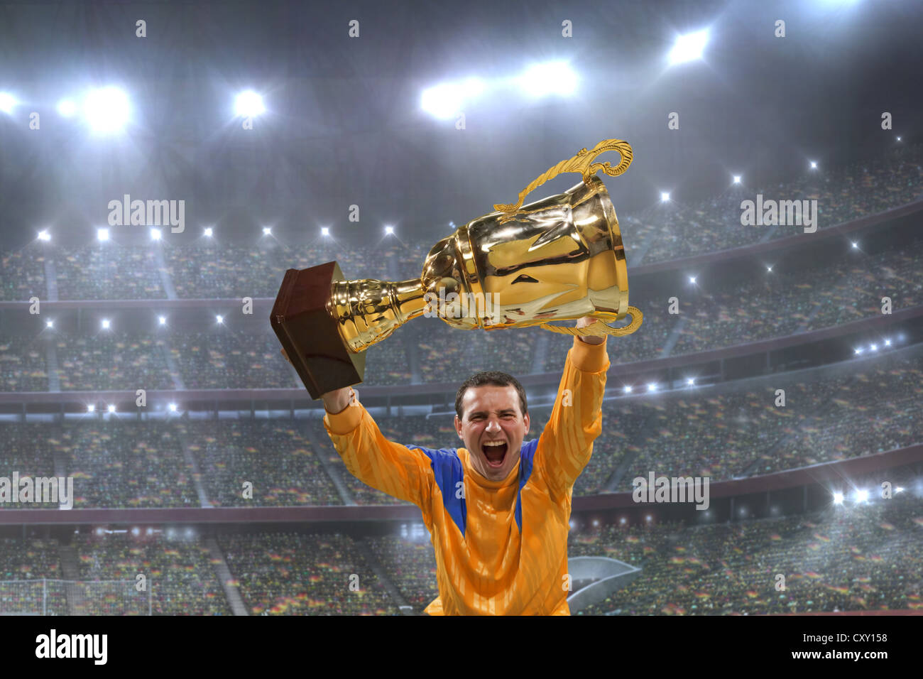 Football player holding up trophy, cheering, winner, winning, confetti, football stadium Stock Photo