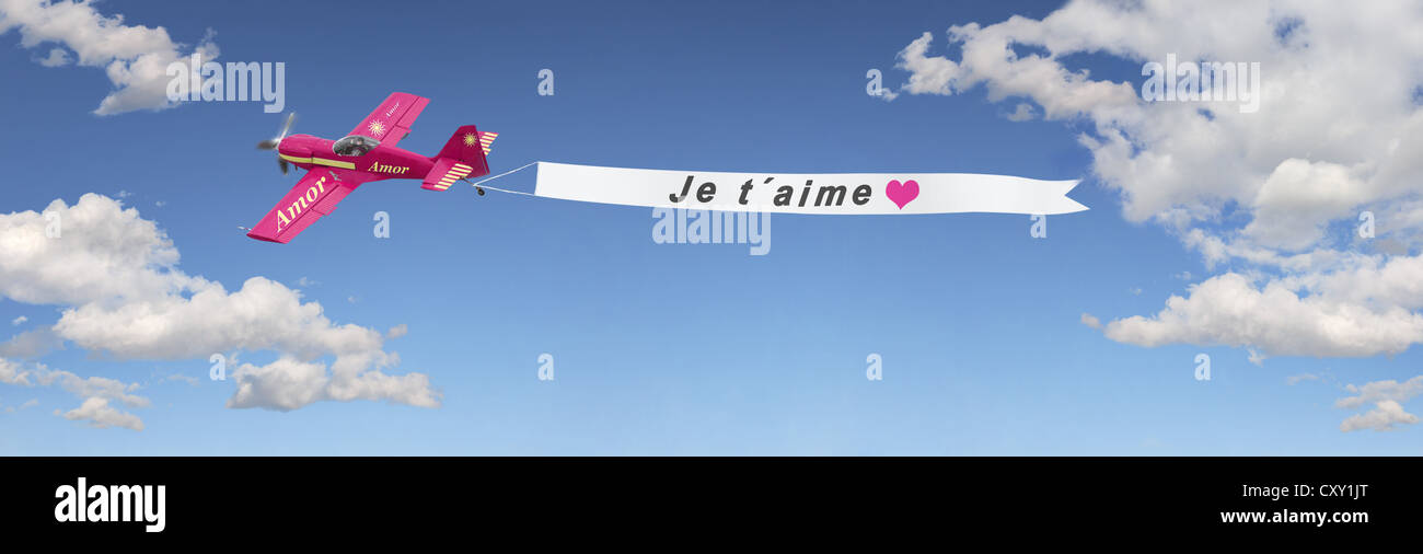 Plane in the sky pulling a banner with the message Je t'aime, French for I love you, illustration Stock Photo