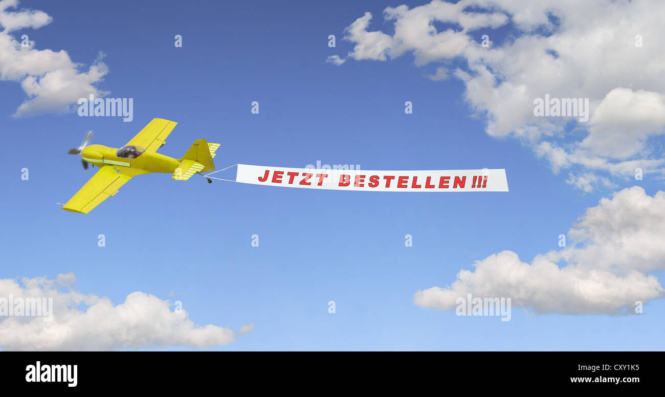 Plane in the sky pulling a banner with the message Jetzt Bestellen, German for Order Now, illustration Stock Photo