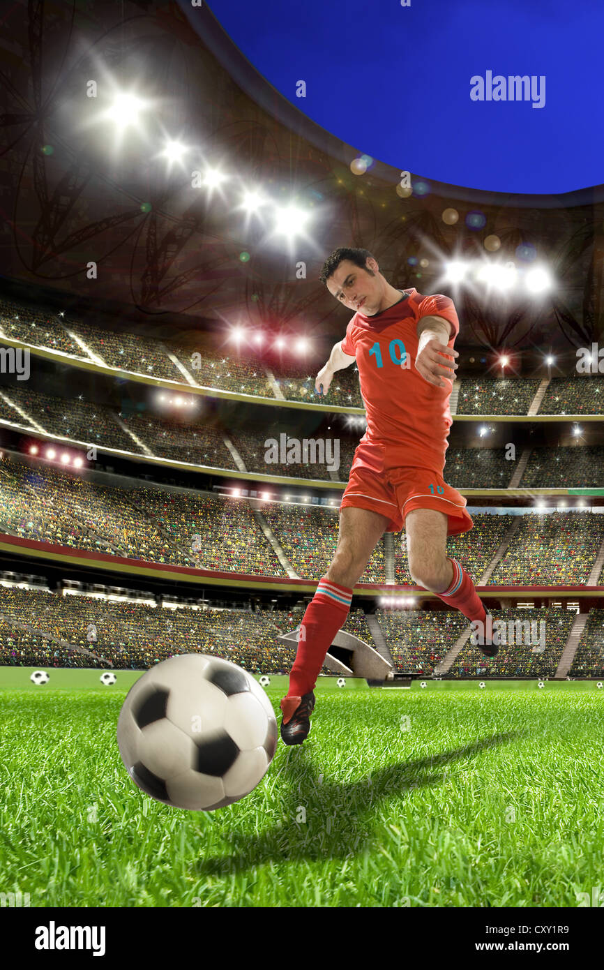 Soccer player kicking a soccer ball, soccer stadium Stock Photo