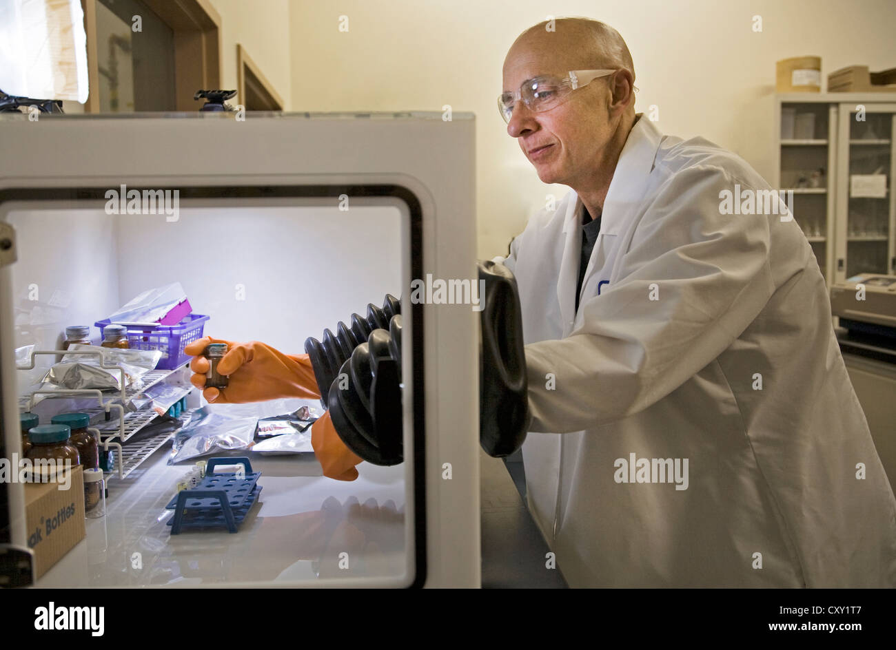 A chemist dressed in safety gear works in research at a at a