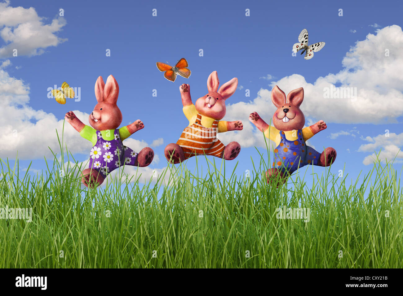Three Easter bunnies jumping in a meadow, illustration Stock Photo Alamy