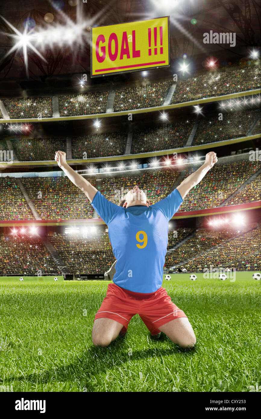 Cheering soccer player, scoreboard, lettering 'Goal', soccer stadium Stock Photo